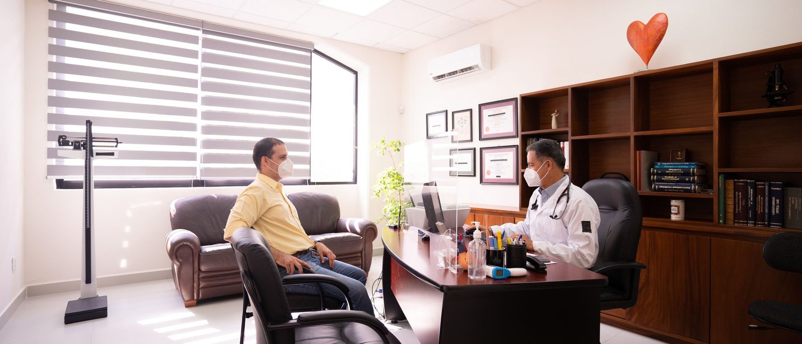 Doctor checking a patient's blood pressure in a clinic consulting room