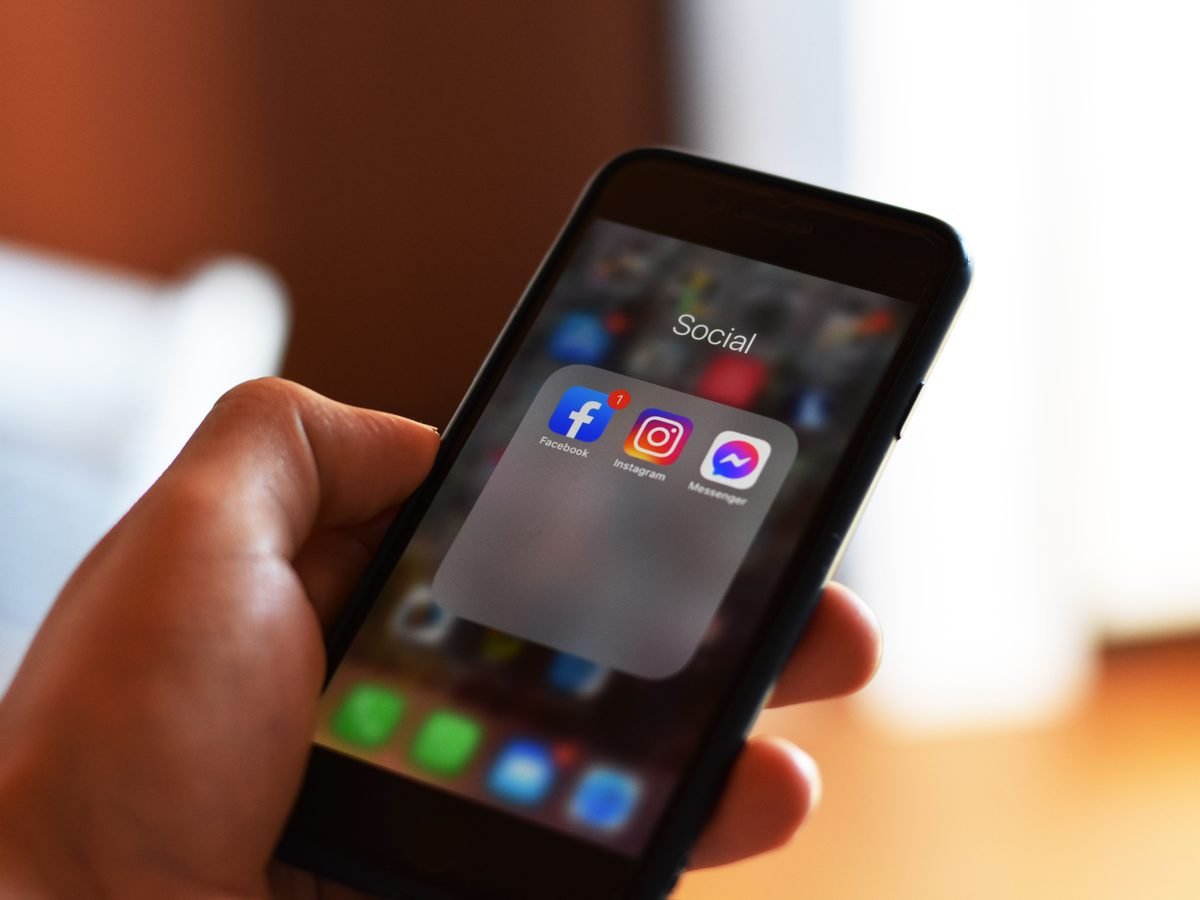 Hand holding a phone with social media apps open